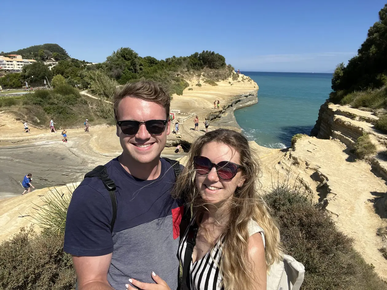 Selfie von Max und Rebecca auf den hellen Sandsteinfelsen, hinter ihnen ein schmaler Kanal zum Meer