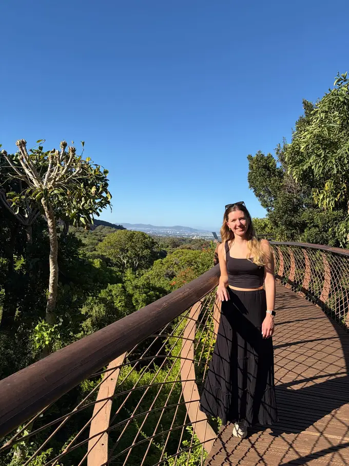 Rebecca steht auf dem Baumwipfelpfad von Kirstenbosch, umgeben von den Kronen hoher Bäume
