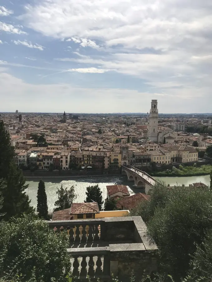 Blick von oben über eine Balustrade auf die Etsch mit einer Brücke und die Altstadt von Verona