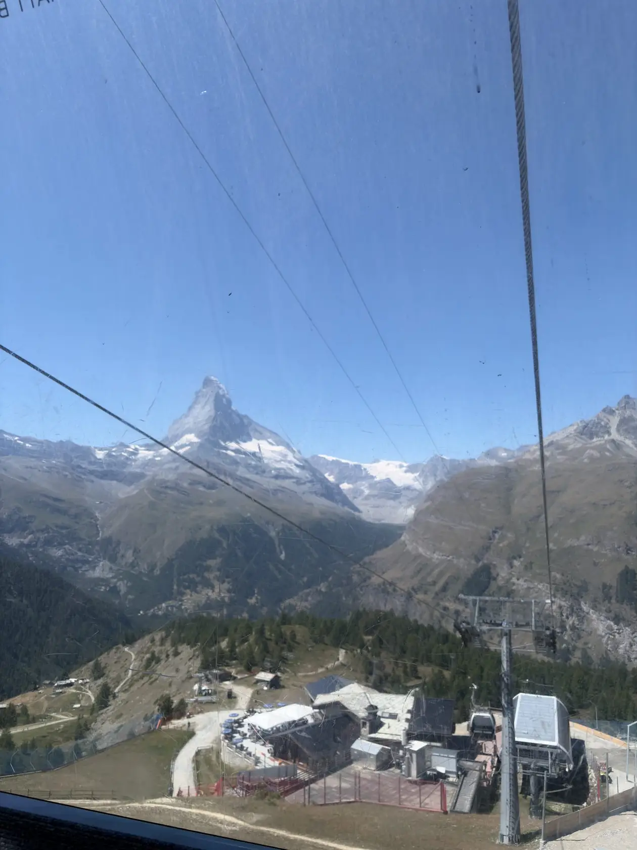 Blick aus der Gondel auf das Matterhorn, darunter eine Bergstation und Seile