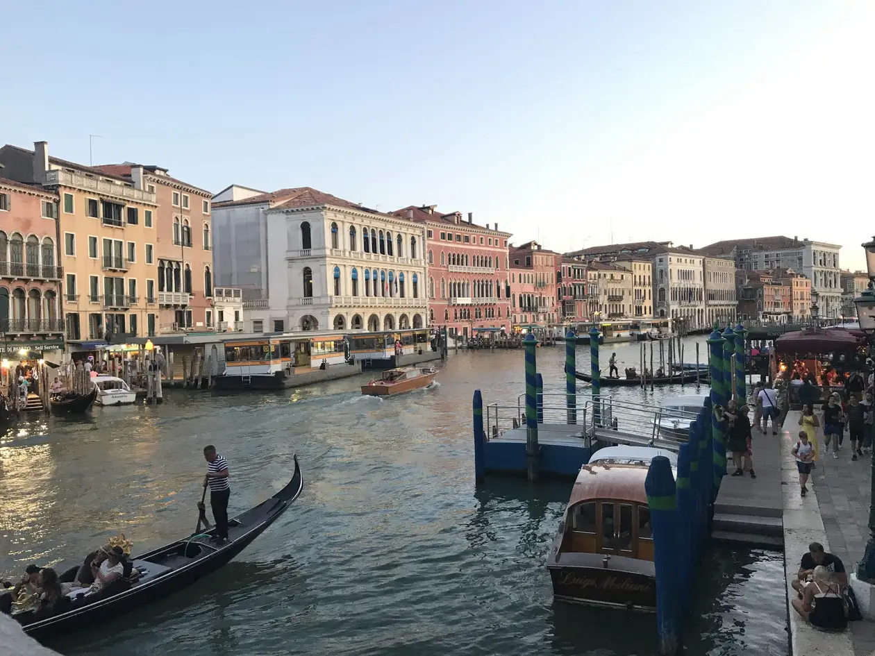 Der Canal Grande im Abendlicht mit einer Gondel, Anlegern und einer Reihe von Palästen
