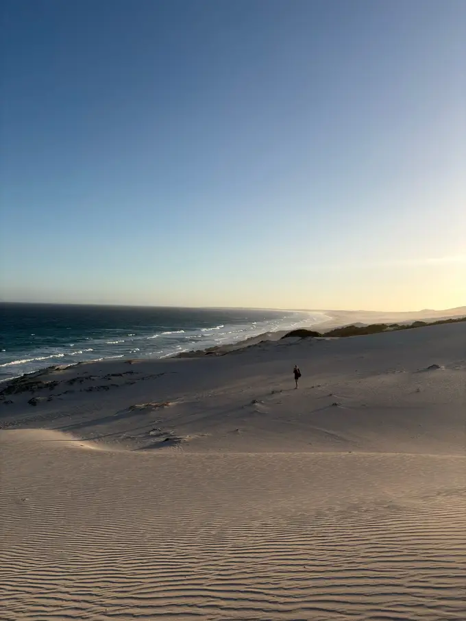 Weite weiße Dünenlandschaft im Abendlicht mit Blick aufs Meer