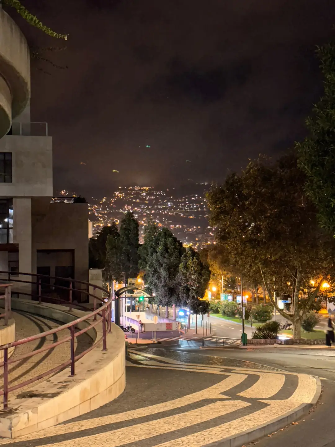 Nächtlicher Blick von einer Treppe auf die beleuchtete Häuserschale von Funchal am Hang