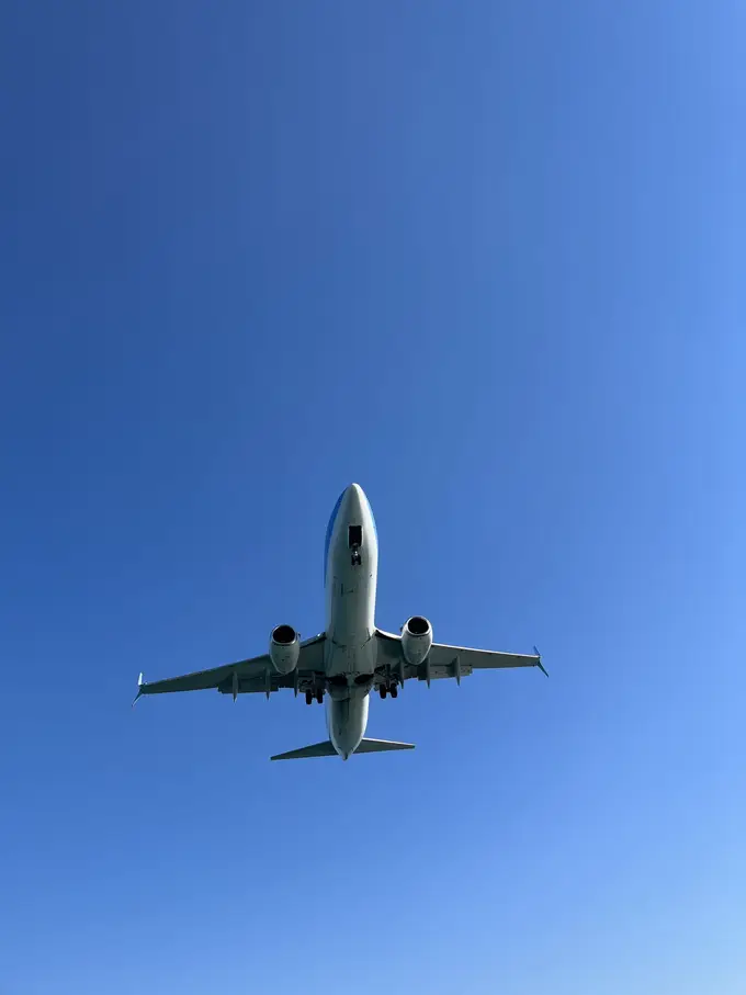 Ein Passagierjet von unten, direkt über der Kamera, mit ausgefahrenem Fahrwerk