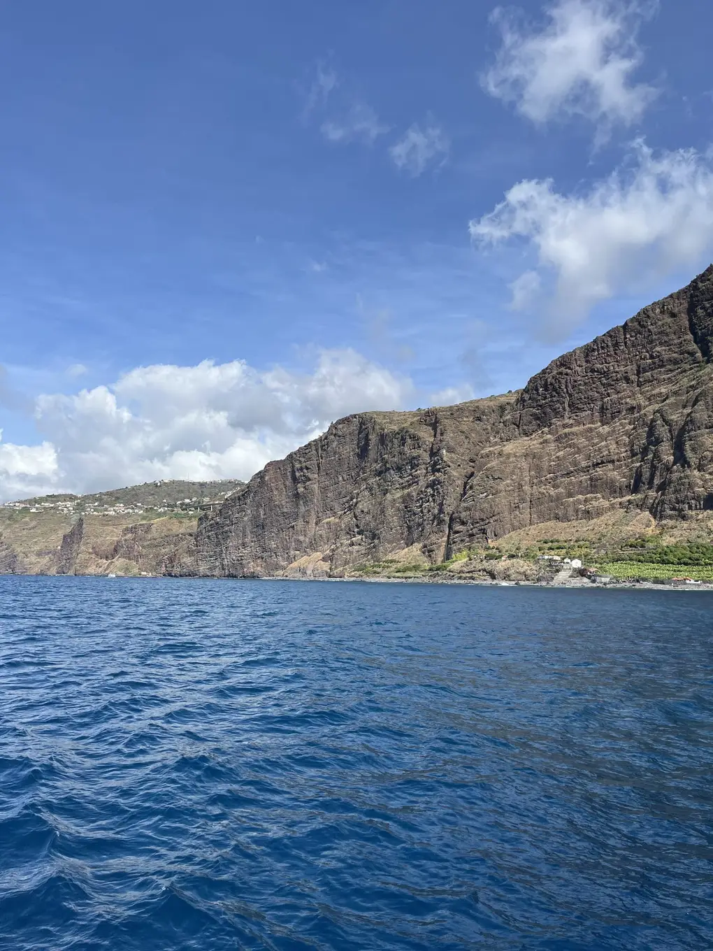 Hohe Felsklippen entlang der Küste, im Vordergrund das Meer