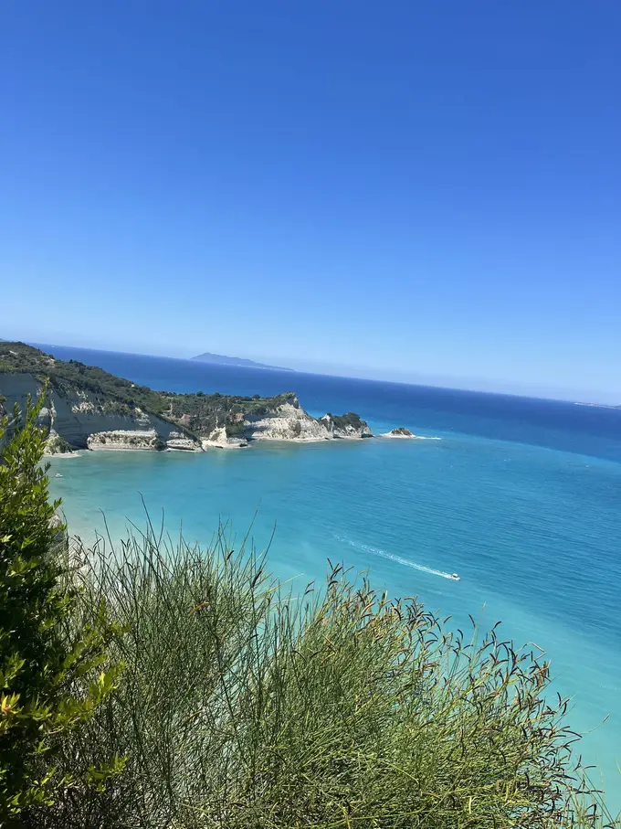 Blick über türkises Wasser auf eine Küste mit hellen Klippen