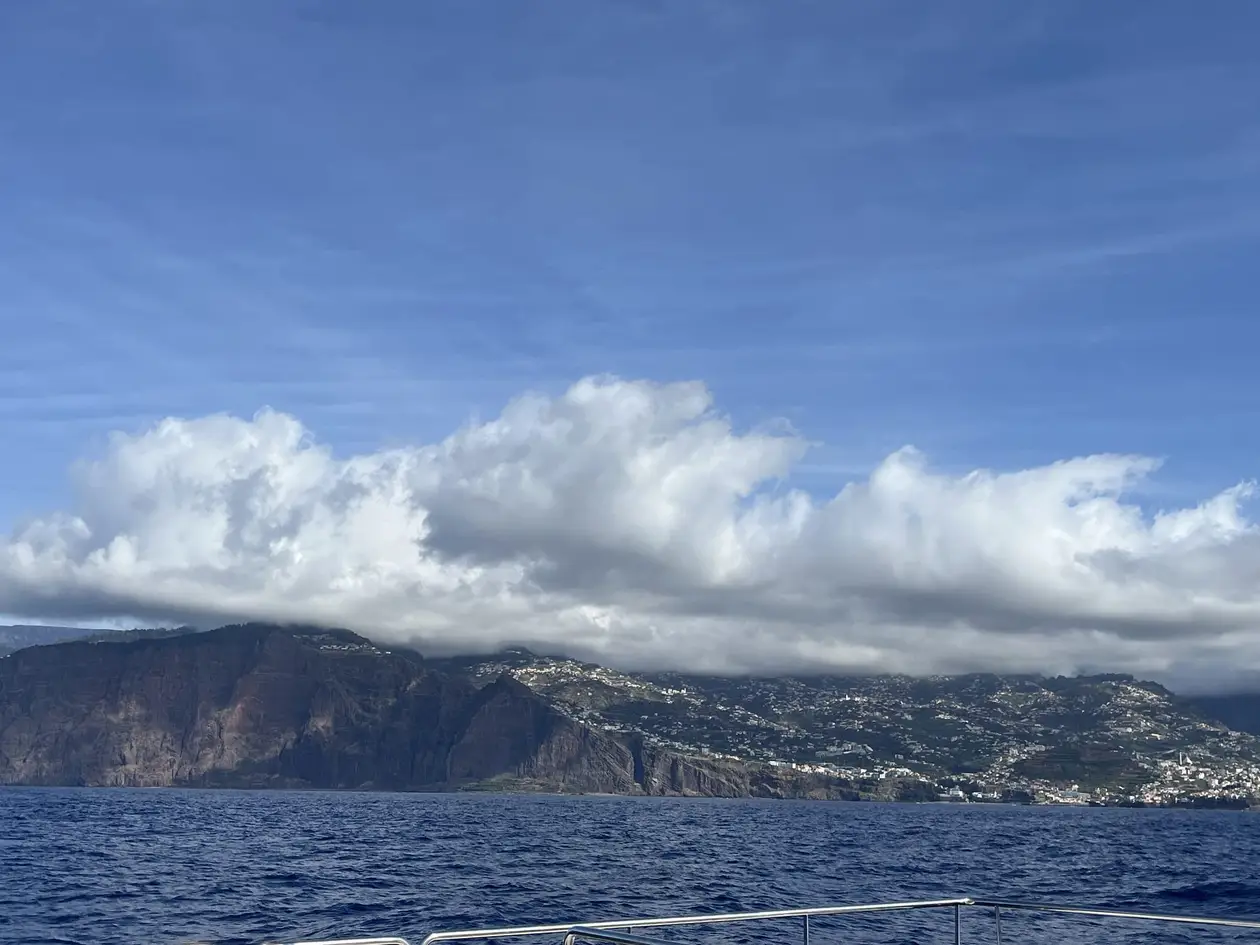 Steilküste mit Wolken, gesehen von der Reling eines Ausflugsboots