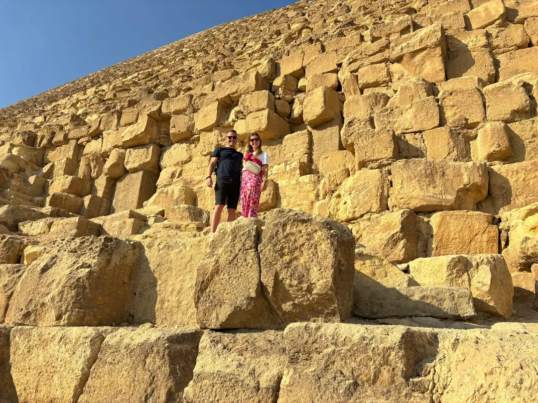 Max und Rebecca stehen auf einem der unteren Steinblöcke einer Pyramide, über und neben ihnen weitere mannshohe Blöcke