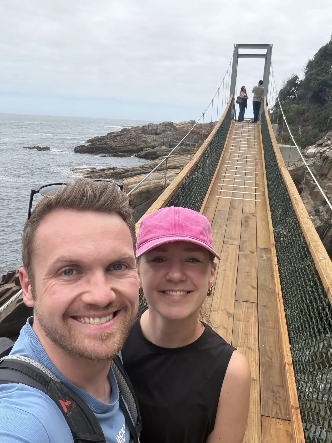 Max und Rebecca lächeln vor der Hängebrücke über die Mündung des Storms River