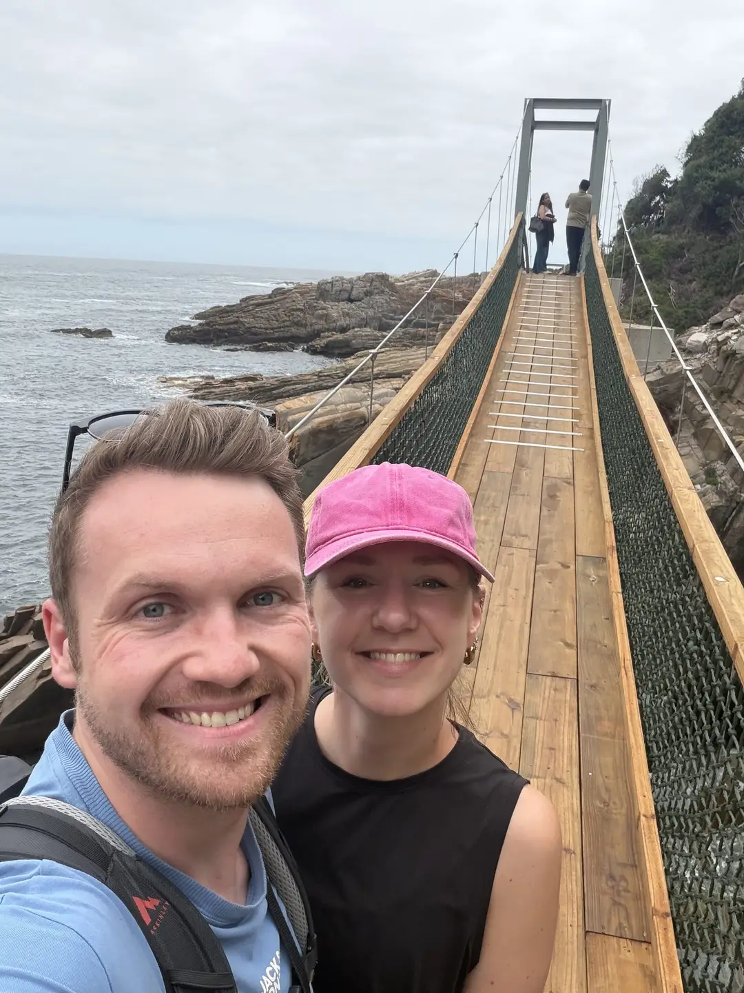 Max und Rebecca lächeln vor der Hängebrücke über die Mündung des Storms River