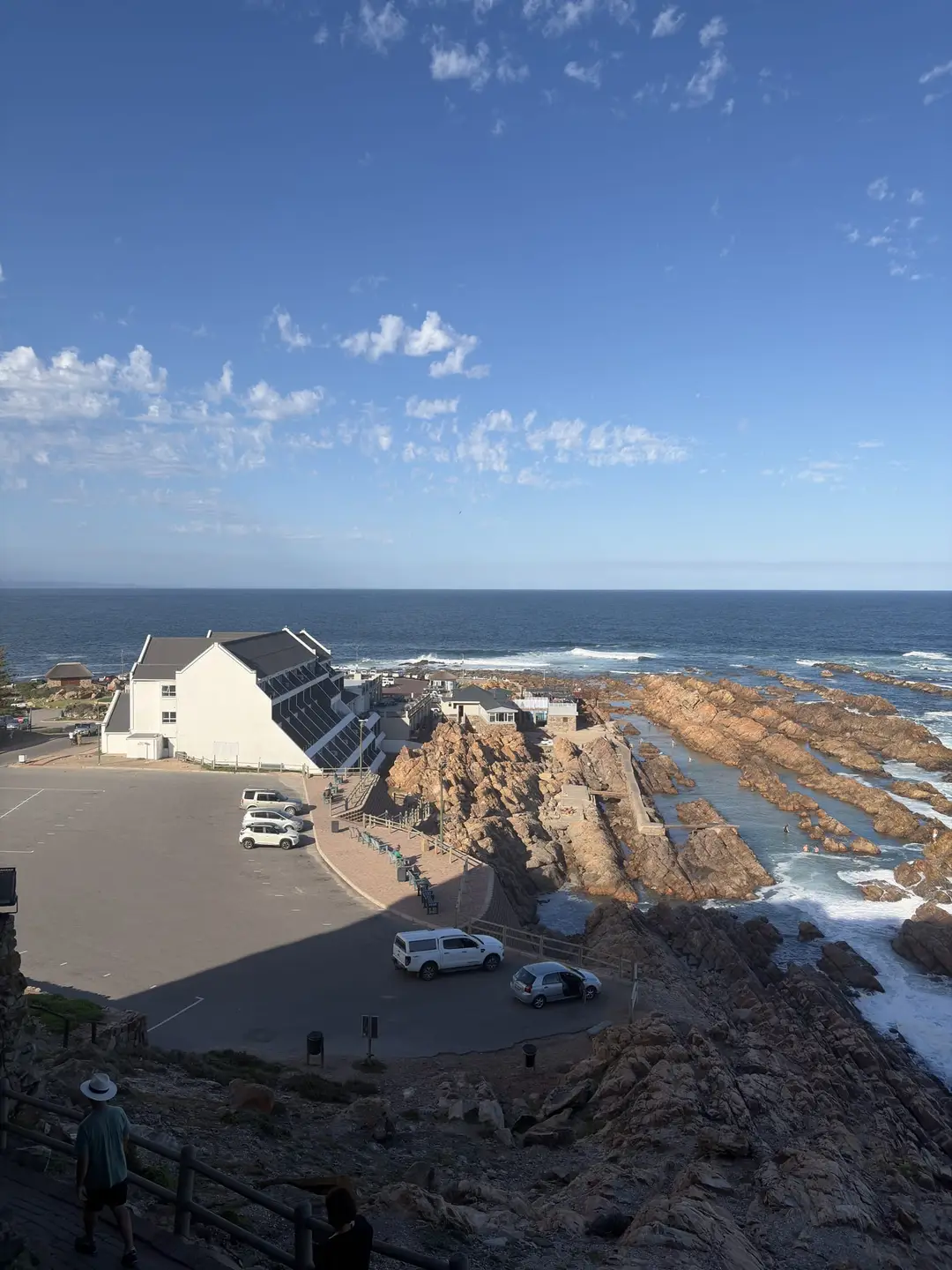 Blick von der Klippe auf die Küste bei Mossel Bay mit Felsen und Meer