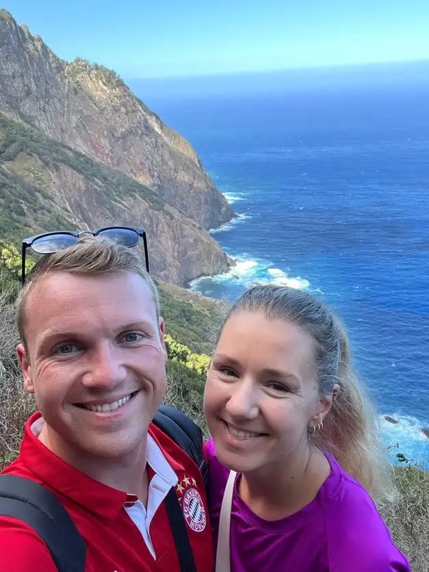 Zwei Personen vor einem Panorama aus Steilküste und Meer