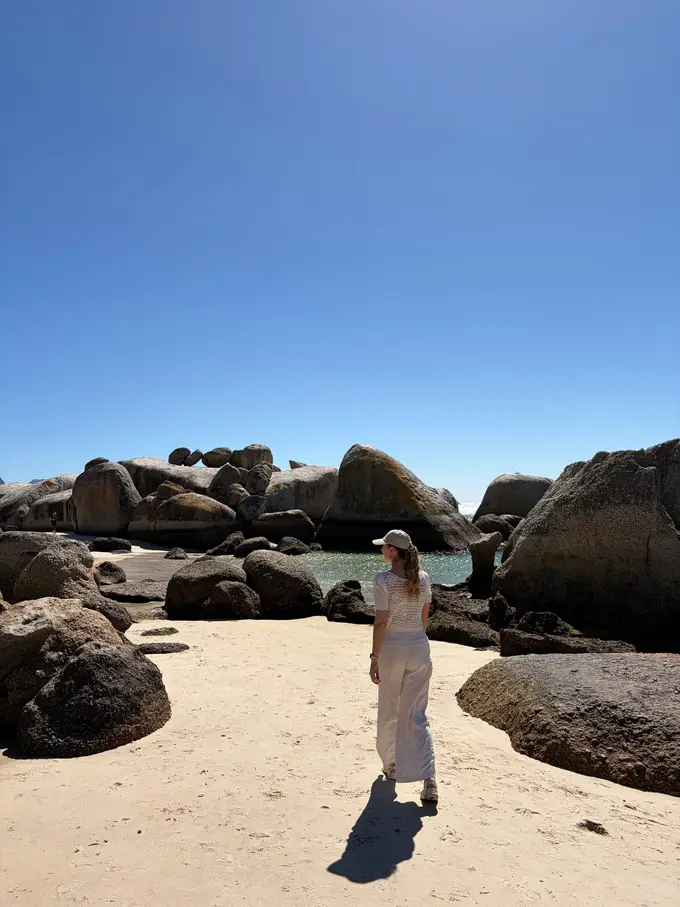 Rebecca von hinten zu sehen, wie sie zwischen den namensgebenden großen Granitfelsen von Boulders Beach geht