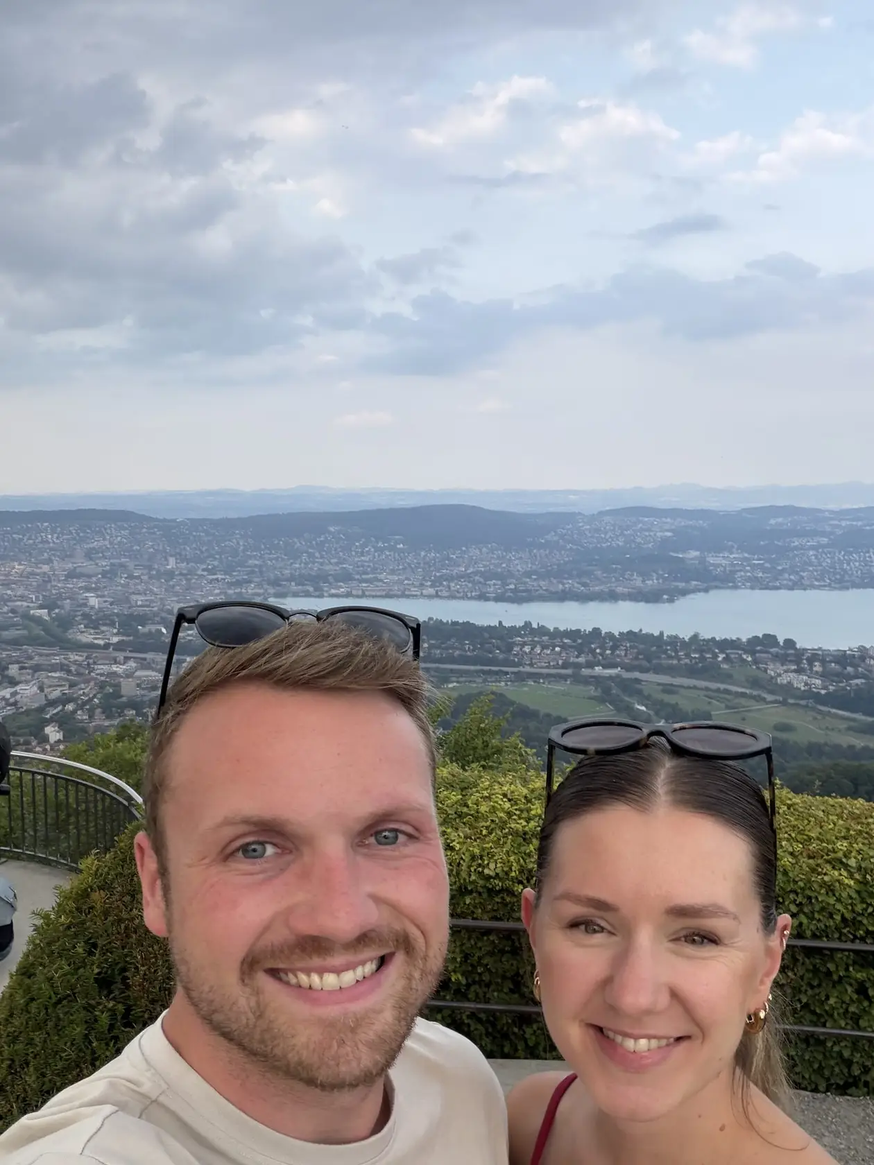 Selfie von Max und Rebecca an einem Aussichtspunkt, hinter ihnen Zürich und der See von oben