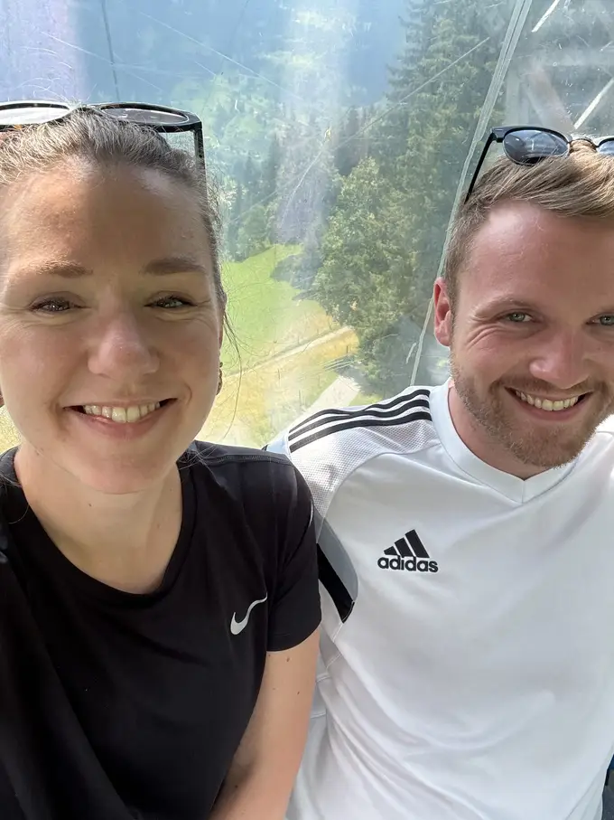 Selfie von Rebecca und Max in einer Gondel, hinter der Scheibe Wald und Wiesen weit unten