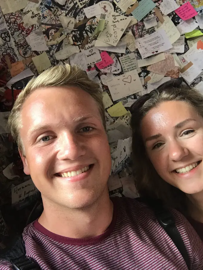Selfie von Max und Rebecca vor einer Wand, die dicht mit Zetteln und Notizen beklebt ist