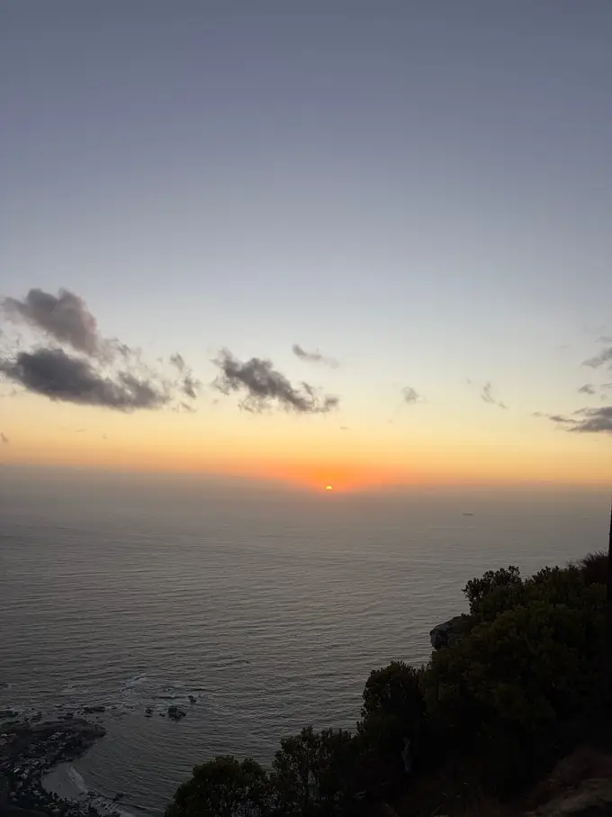 Die Sonne geht orange über dem Atlantik unter, vom Gipfel des Lion's Head aus gesehen
