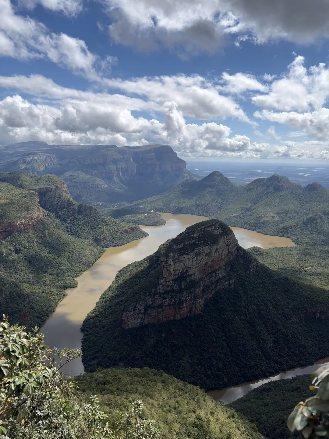 Weiter Blick auf drei runde bewaldete Felskuppen über einer Flussschleife im Blyde River Canyon