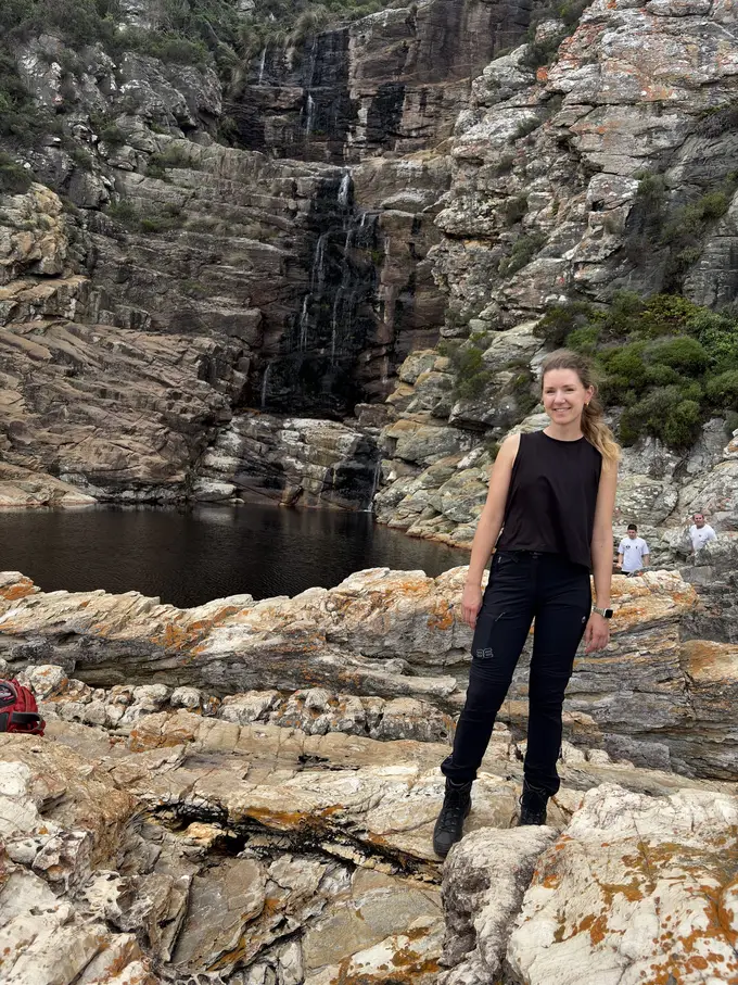 Ein Wasserfall stürzt über gestufte Felsen in ein dunkles Becken