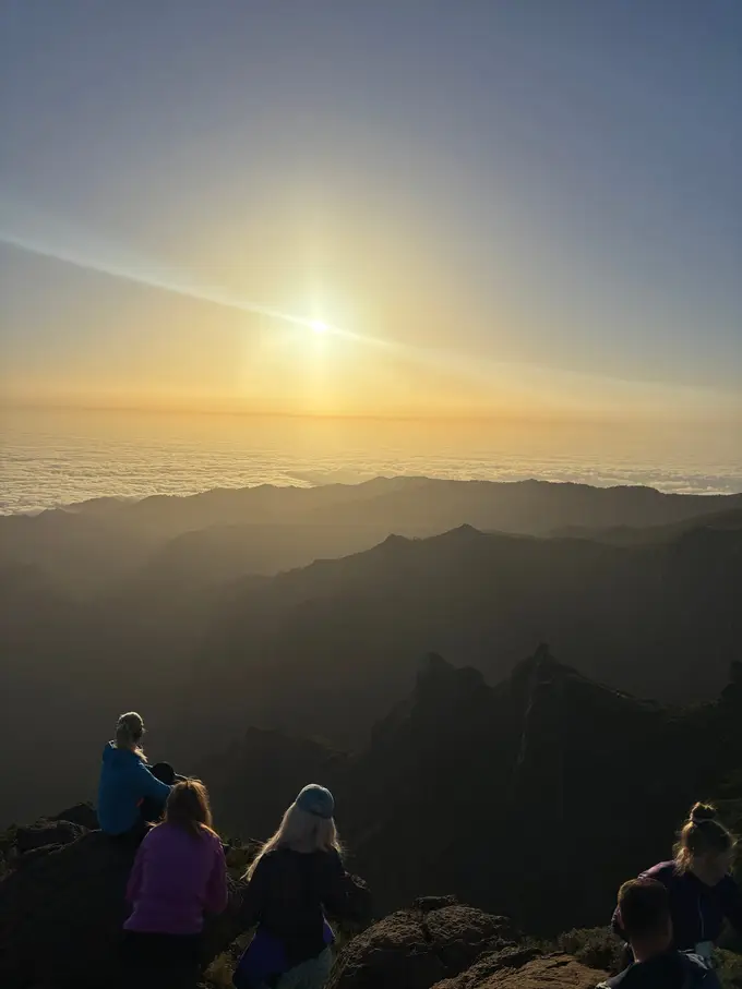 Geschlossenes Wolkenmeer im warmen Morgenlicht, einzelne Gipfel ragen daraus hervor