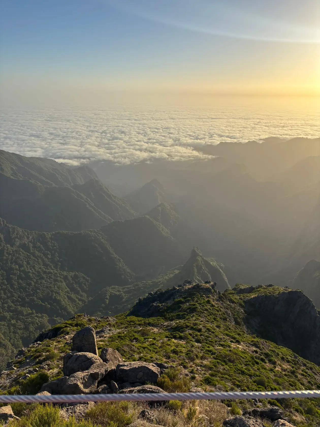 Geschlossenes Wolkenmeer im Morgenlicht, aus dem nur die höchsten Gipfel herausragen